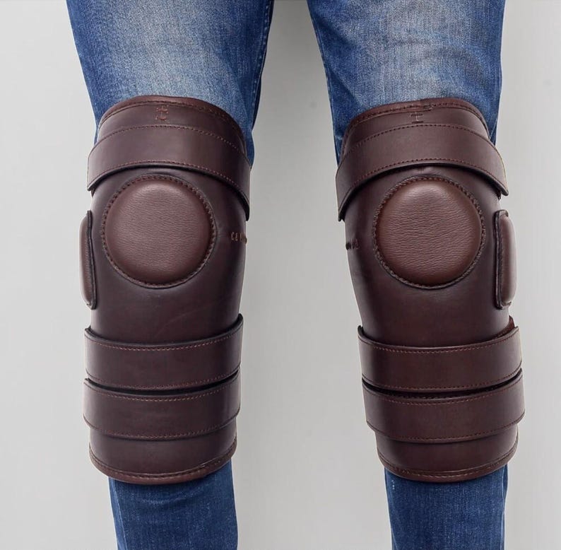 Rider wearing brown leather polo knee guards over jeans