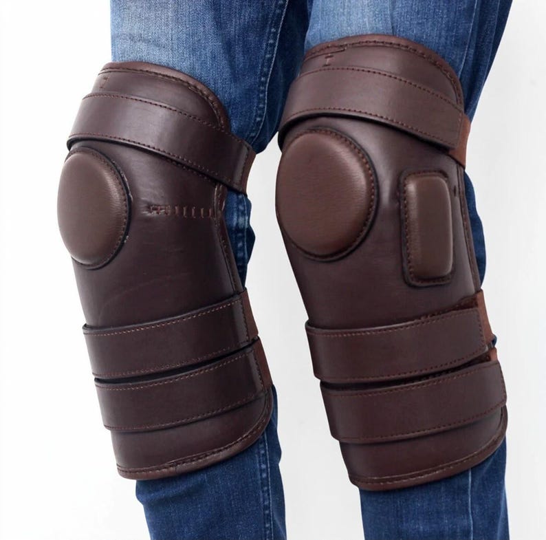 Dark brown leather polo knee guards with padded knee cushion and three adjustable straps