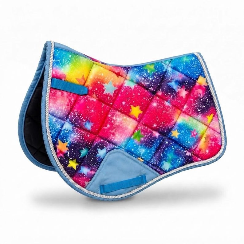 Quilted rainbow galaxy saddle pad with colorful stars and blue binding