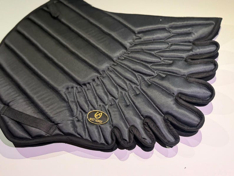 Close-up of black quilted angel wing saddle pad feather detail and gold Best Horse patch